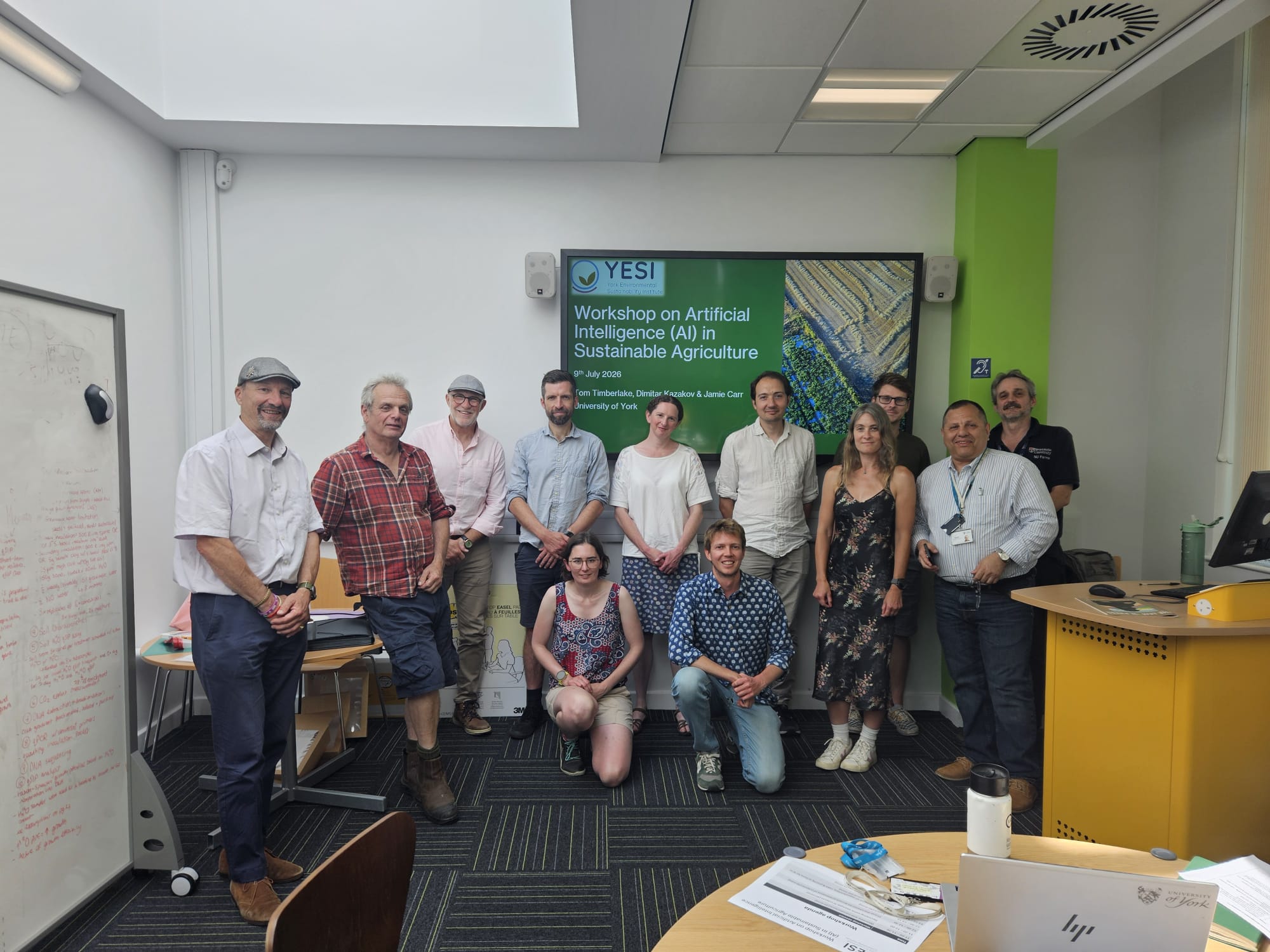 Workshop attendees stood in front of a presentation screen.